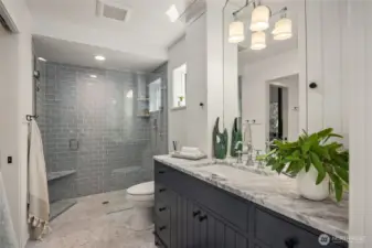 The primary bath has a gorgeous walk in shower, marble flooring and beautiful cabinetry!