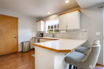 Kitchen featuers SS appliances, a breakfast bar and window looking out to the backyard.  Access to garage off kitchen