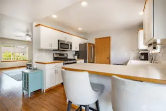 Kitchen featuers SS appliances, a breakfast bar and window looking out to the backyard.  Access to garage off kitchen