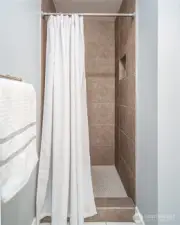 A walk-in shower with beautiful tile work completes the space.