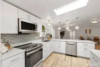 Modern kitchen with tile backsplash, skylight, and ample counter space.