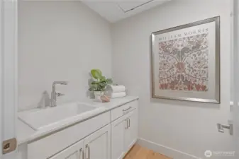 Laundry room with sink and cabinets. Engineered hardwood floors.