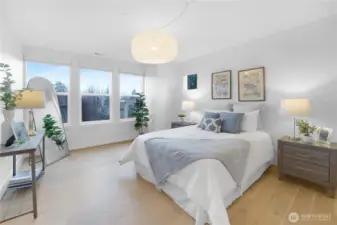 Upstairs, the spacious primary suite feels large and airy, highlighted by a distinctive light fixture and those gorgeous hardwood floors. Just beyond the frame, a convenient barn door leads to the private primary bath and walk-in closet, completing this serene retreat.