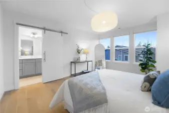 The entrance to the primary bath reveals a thoughtful layout, with a soaking tub to the right and a sleek shower to the left.  Beyond the shower lies the spacious walk-in closet, complete with an organizer system for effortless storage and style.