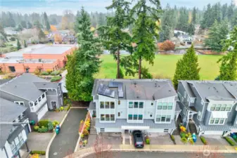 From above, the drone captures the home’s solar panels, a modern upgrade that blends sustainability with style. The surrounding neighborhood comes into view, with the green soccer fields of a nearby school adding a sense of openness and spaciousness to the outdoor setting.