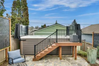 This 16 foot, energy-efficient Vita Spa swim spa—with a Smart Top and hydrotherapy jets—stands on the fenced back patio between the house and the 2-car detached garage.