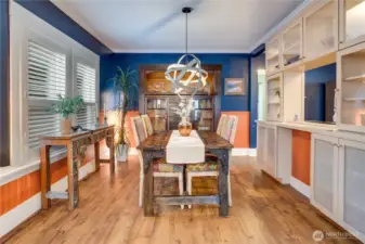 A cased opening leads from the living room into the dining room with its original hutch, and classic details like crown molding and wainscot. Notice how the cabinetry doesn't end in the kitchen, but extends to the dining room for additional cupboard storage.