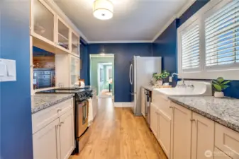 Custom blinds, fresh paint, and new flooring extend throughout the whole main floor for continuity. The kitchen leads to a back hall with a 1/2 bath, laundry room, and a home office.