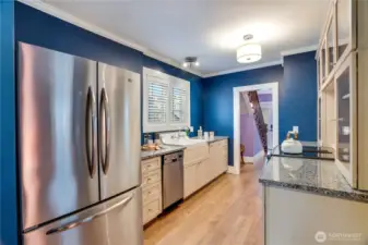 The kitchen includes a complete set of appliances: a Jenn Air oven with an induction range, a compact dishwasher, and the refrigerator/freezer.