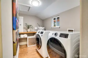 Find the laundry room right across the hall from the main floor bath. Control washer and dryer loads remotely with an app if you like. The water heater stands in the corner and the window overlooks the covered back deck.