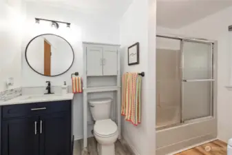 Lower level full bath with updated flooring, cabinet/vanity, mirror & lighting.