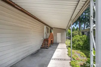 Another view of the carport and attached storage unit.