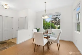 Charming dining area with large windows overlooking a beautiful landscape, perfect for enjoying natural light and seasonal views.