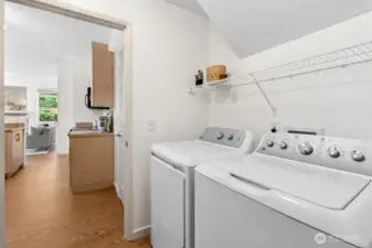 Laundry room with brand-new GE washer and dryer plus overhead shelving for household essentials.