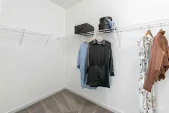 Spacious primary walk-in closet with built-in shelving, ready for your wardrobe today and the custom closet of your dreams tomorrow.