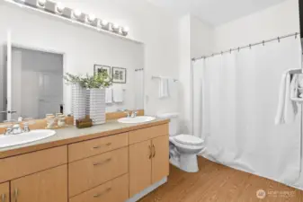 Primary ensuite bathroom with dual sinks, ample counter space, and a full tub and shower.