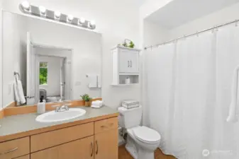 Hall bathroom with full tub and shower, single-sink vanity, and upgraded Toto toilet.