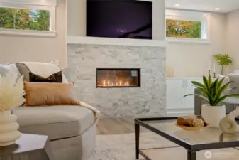 Relax and unwind by the fire in this peaceful, light-filled living room.