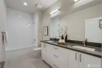 Stylish upper-level full bath with dual sinks and a clean, modern tile surround—ideal for shared use.