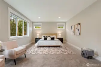 Spacious primary suite with large windows capturing the natural landscape and inviting morning light.