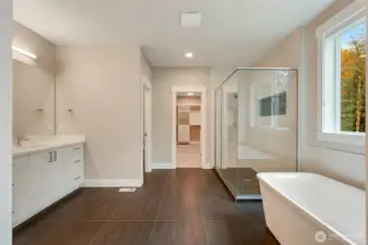 Spa-inspired primary bath with a soaking tub overlooking the trees and a walk-in glass shower for everyday retreat living.