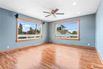Another view in great room showing real hardwood floors and ceiling fan.