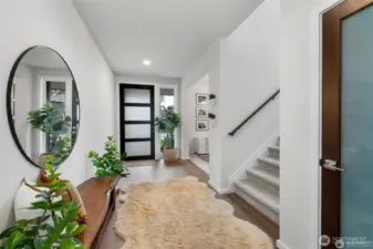 Stepping through the inviting entryway, you find yourself in a spacious, light-filled foyer. Large windows invite in natural light, creating an airy atmosphere.