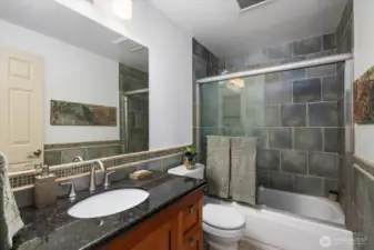 Beautiful hallway bathroom with a large vanity, gorgeous tiling and detailing throughout!