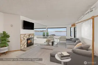 Another perspective of the exceptionally wide living room, showcasing its generous proportions and seamless sense of openness. The space is anchored by an expansive picture window that floods the room with natural light, creating a bright and inviting atmosphere while offering unobstructed views outside.