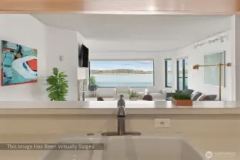 This thoughtfully designed floorplan showcases a seamless flow from the kitchen into the dining and living areas, all oriented toward a stunning, expansive view. The open-concept layout creates a bright, inviting atmosphere that’s perfect for both everyday living and entertaining. Here, even routine tasks take on a new appeal—cooking and cleaning become enjoyable experiences as you stay connected to the space around you and the scenery beyond. Living here means turning once-ordinary moments into something truly special.