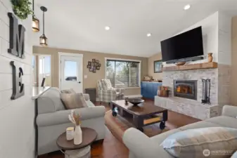 Living Room with wood burning fireplace with a brick surround.