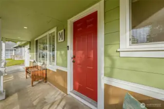 A covered front patio welcomes you to an inviting front door.