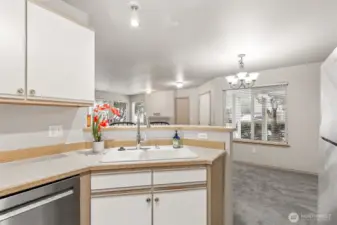 Kitchen Opens to Dining Area with Vew of Entry Patio & Parking Space