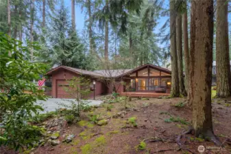 Tucked among mature evergreens, this home offers a peaceful, private setting.