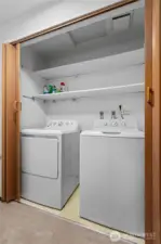 Dedicated laundry area with additional storage space.