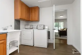 An abundance of storage, the laundry room offers built-in cabinets, laundry sink plus two storage closets