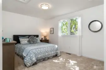 Generous secondary bedroom with front yard views, accommodates a queen-sized bed and dresser