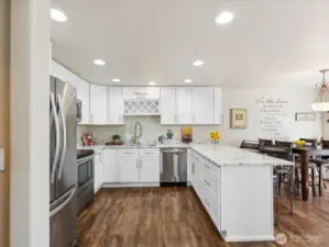 Gorgeous updated Kitchen is bright & open - with granite counters, stainless appliances & Sitting bar.