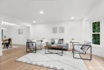 Enter to the main living area, featuring a bay window, luxury vinyl plank flooring, fresh paint, craftsman trim, and adjustable canless lighting.