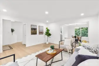 Enter to the main living area, featuring luxury vinyl plank flooring, fresh paint, craftsman trim, and adjustable canless lighting. Adjoining formal dining room with tray ceiling and chair rail molding.