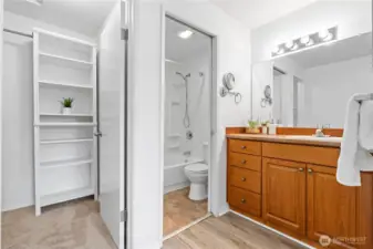 En-suite primary full bathroom with a pocket door separating the water closet and bath tub, walk-in closet with built-in shelving.