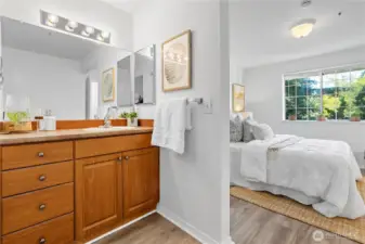 The primary bedroom and vanity sink area updated with engineered hardwood flooring. Bath tub and water closet is separately enclosed by a pocket door.