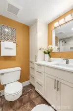 Full bath with stone tile flooring.