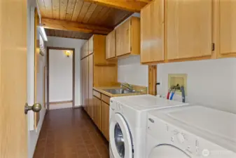The main floor laundry room includes a utility sink and abundant storage space.