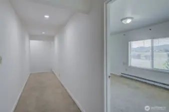 Hallway leads to primary suite. Bedroom 2 on the right.