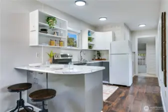 Bright, fresh, and open—this kitchen features newly painted cabinets, a sunny window over the sink, and a bar that’s perfect for quick bites or catching up with friends.