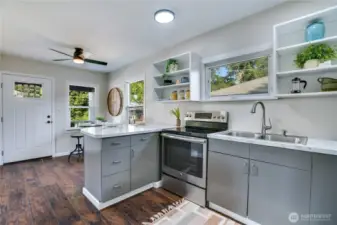 Designed for both form and function, this kitchen shines with crisp cabinetry, a five-burner range, and seamless transitions to the dining and living areas.