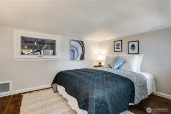 The primary bedroom features a spacious layout, bright windows, and room for dressers and added storage.