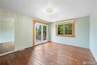 Primary bedroom with French doors that open to back porch.
