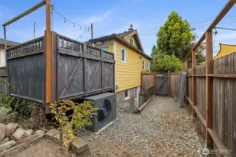 Side yard with possible dog run, includes basement access and access to AC unit and garden.